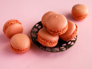three pink pastel macaroons close-up on vintage metal plat on purple background