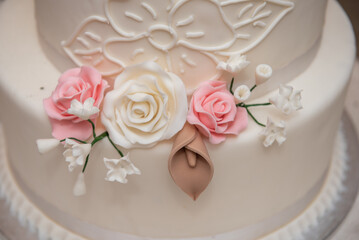 The bride's cake with white and pink roses at the wedding