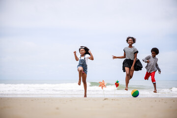 group of childhood friends jumping happily on a tropical beach. Ethnically diverse concept