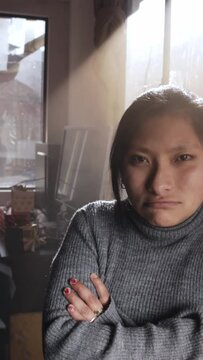 Vertical footage of a Hispanic female crossing her hands with unsatisfied look