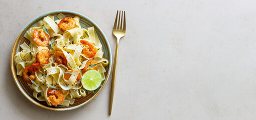 Pasta fettuccine in a creamy sauce with shrimp, lime and sage. Italian food.