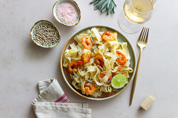 Pasta fettuccine in a creamy sauce with shrimp, lime and sage. Italian food.