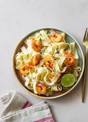 Pasta fettuccine in a creamy sauce with shrimp, lime and sage. Italian food.