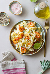 Pasta fettuccine in a creamy sauce with shrimp, lime and sage. Italian food.