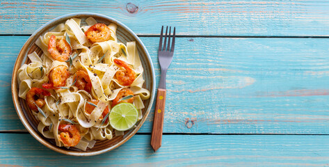 Pasta fettuccine in a creamy sauce with shrimp, lime and sage. Italian food.
