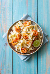 Pasta fettuccine in a creamy sauce with shrimp, lime and sage. Italian food.