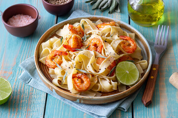 Pasta fettuccine in a creamy sauce with shrimp, lime and sage. Italian food.
