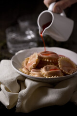 Dumpling with sauce, on a dark background, food photography.