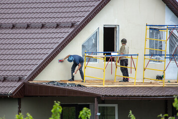 Workers are plastering the walls of the house.