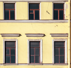 Fototapeta na wymiar Windows on the wall of an old high-rise building.