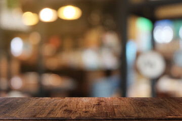 Empty dark wooden table in front of abstract blurred bokeh background of restaurant . can be used for display or montage your products.Mock up for space.