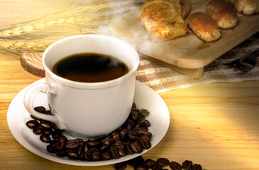 Coffee break at morning time,coffee cup and roasted coffee beans on wooden table with a sunlight