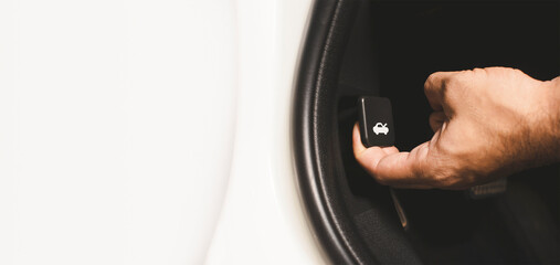 Pulling the vehicle hood button by driver hand with horizontal copy space on white background