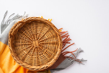 Autumn aesthetic concept. Top view photo of empty wicker basket and plaid on isolated white...