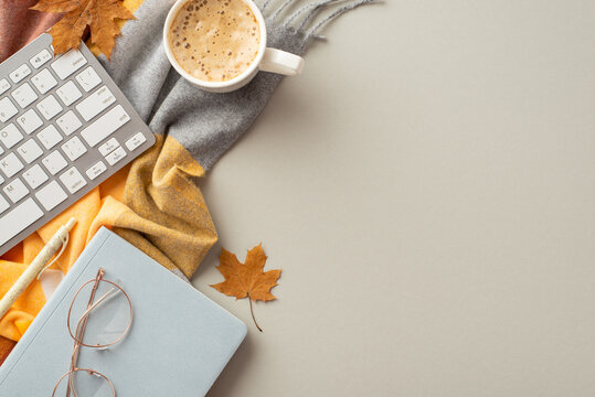 Autumn business concept. Top view photo of workplace keyboard reminder pen stylish glasses cup of frothy coffee fallen maple leaves and scarf on isolated grey background with copyspace