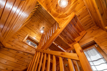 Bottom up view of wooden stair with railing in a country house. Cozy atmosphere of country house