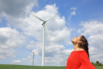 Woman in red breathing fresh air in a wind farm