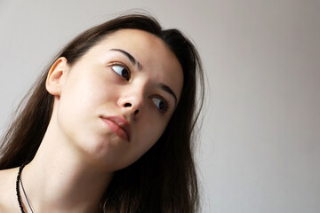 Fototapeta premium Portrait of attractive teen girl with long hair looking to the right. Female beauty, skin and hair care