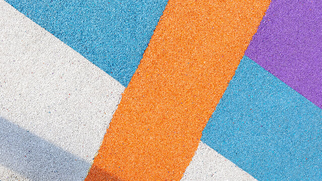 Special rubber coating for playground or sports activity. Junction of multicolored pieces of floor covering made of recycled materials. Padded floor covering with rubber granules.