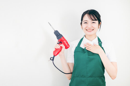 DIYするエプロン姿の日本人女性（ホームセンター）
