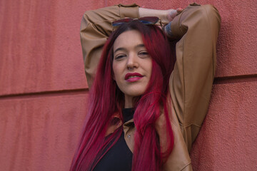 young redhead hipster girl with urban pose on the wall