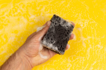 A man washes with a cleaning sponge.
