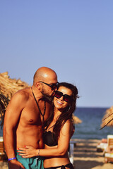 Fototapeta premium Beautiful Happy Couple hugging and kissing enjoying Vacation holidays at luxurious Beachfront villa near the beach