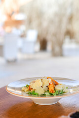 Caesar salad with lettuce,chicken ,parmesan cheese and croutons on wooden table in  a beach restaurant