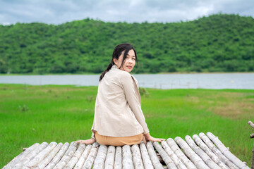 The young woman is sitting on the bamboo litter, turning around and looking at the camera at the...
