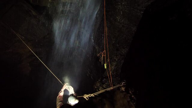 Tyrolean traverse over a waterfall in a cave in Tasmania