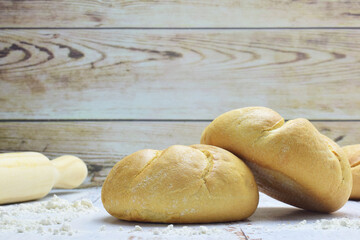 Small round loaves on light colored rustic table.