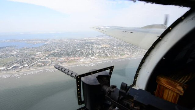 The waist gunner position of a B-17 flying along the coast of Galveston in Texas. 