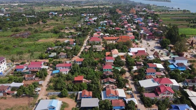 Drone footage above a rural village in Koh Okhna Tey island in Cambodia. Green fields and small houses along the Mekong river 1-2