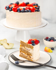 White cake with a wreath made of berries on the white background