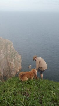 Man in a hat on the mountain with dog