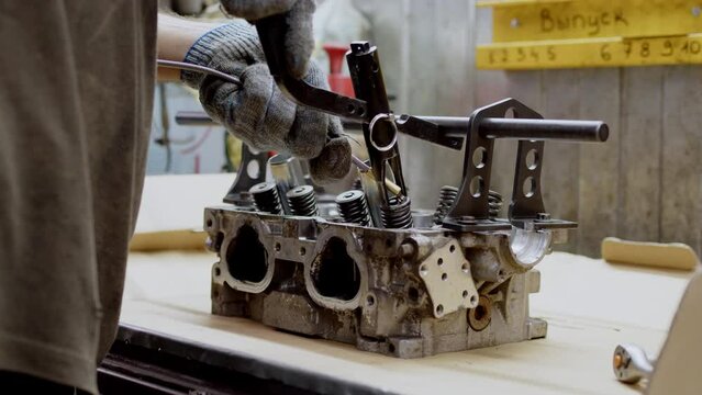 close up view of disassembled sixteen-valve four-cylinder engine. day at car service, engine overhaul, close view of valve stem seals. Beautiful clean silver car engine.