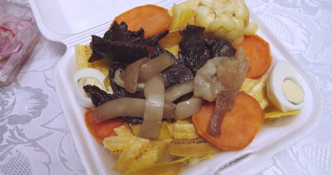 Close-up of Peruvian dish "Carne seca" or biltong with chifles, camote and "maiz".