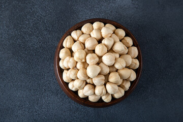 Top view of a bowl full of hazelnuts  on dark background