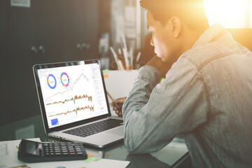 business man finance market analyst working office on laptop while sitting at wooden table.Businessman analyze document in his hands.Graphs and diagram on notebook screen.Blurred


