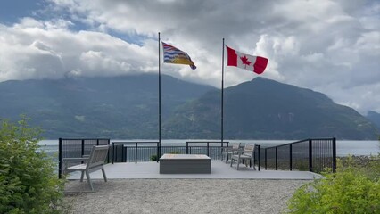 Beautiful shot of two flags in a calm sitting area in Furry Creek, BC, Canada