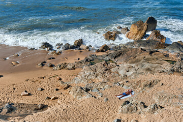 beach and rock and man sunbathing in Foz do Douro, Porto, Portugal