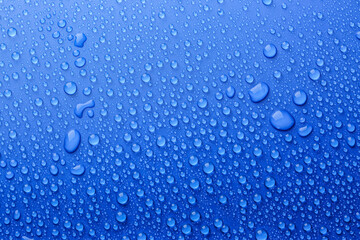 Water drops on blue background, top view