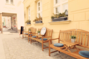 Blurred view of outdoor cafe with wooden benches