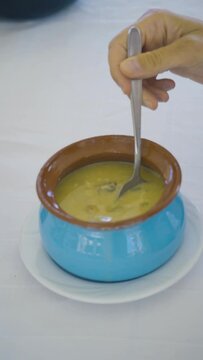 Fish soup in a blue painted clay pot.