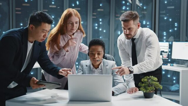 Close up team of multi-ethnic IT specialists communicating in server room. African american woman administrator wearing headset for customer support service. Data center.