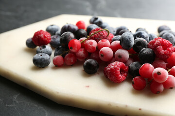 Mix of tasty frozen berries on black table, closeup