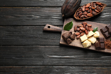 Flat lay composition with organic cocoa butter on black wooden table. Space for text
