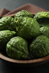 Fresh ripe bergamot fruits in bowl on table, closeup