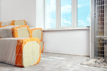 Packages of thermal insulation material in room. Space for text