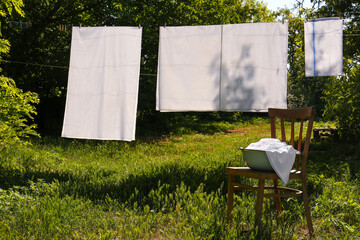 Washing line with clean laundry and clothespins outdoors